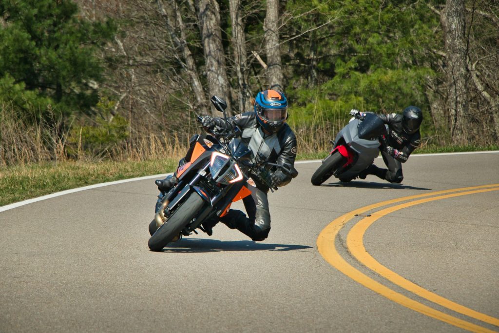 two-motorcyclists-lean-into-a-curve-on-a-road-z_mlgCAahUM